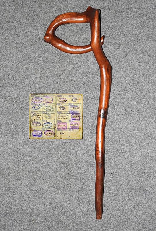 Wanderstab eines Gesellen aus einem verwachsenen Ast gefertigt und Wanderbuch mit zahlreichen Stempeln